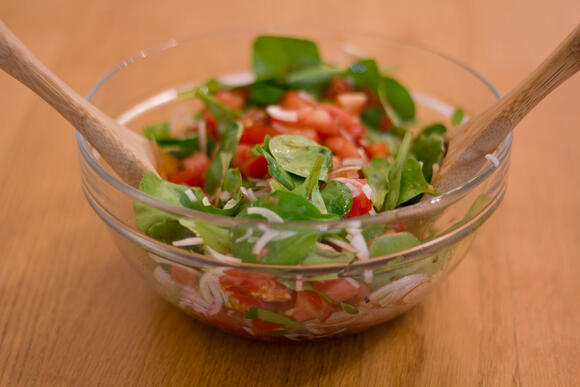 Bild von einer Portion Salat mit Tomate Vogerlsalat und Zwiebel