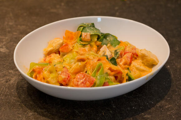 Bild von einer Portion Zucchini-Karotten-Bandnudeln mit Hähnchen und Tomate
